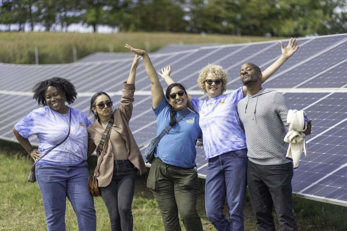 Team photo in front of solar panels during Shepherd's Mill tour